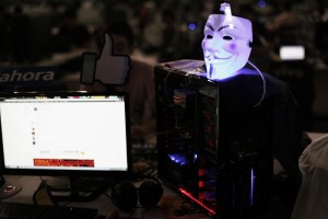 A Guy Fawkes mask is seen on a computer as a man surfs the web during a "Campus Party" Internet users gathering in Sao Paulo