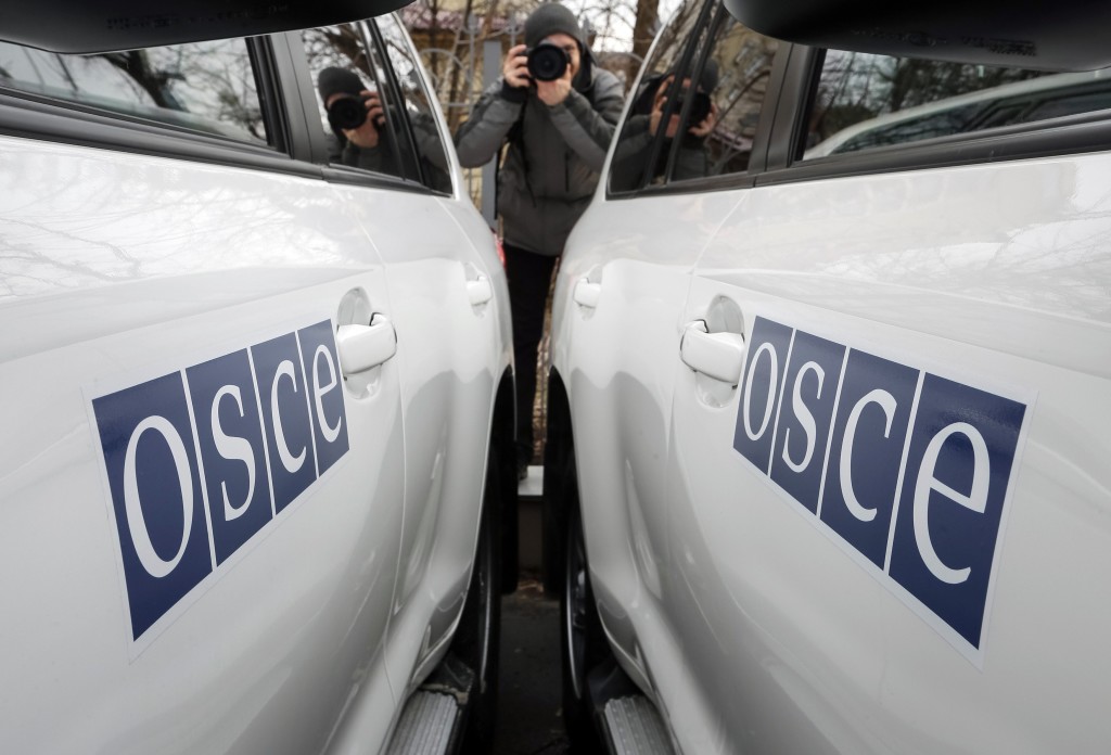 A journalist takes picture during a handover ceremony of armoured vehicles donated by Britain to the OSCE Special Monitoring Mission to Ukraine, in Kiev